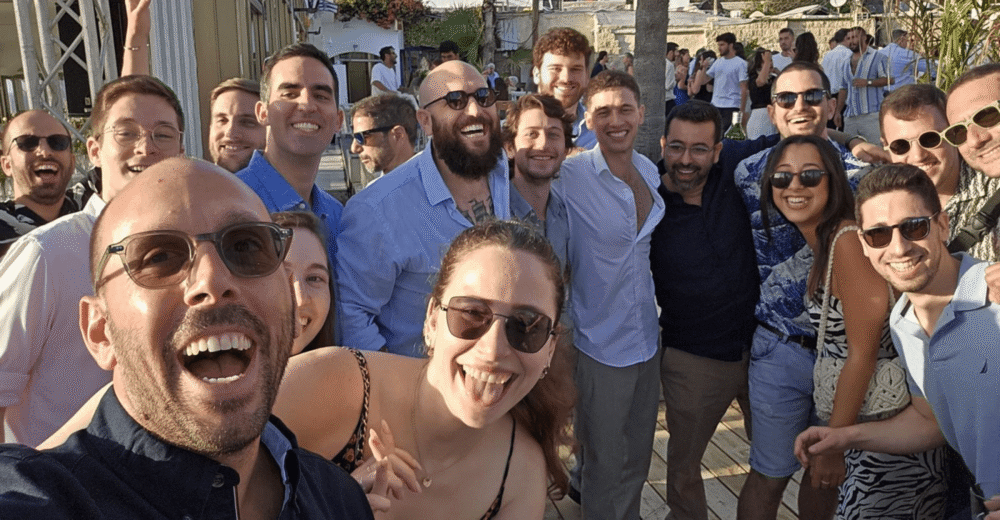 A group of people smiling outside at a vibrant event. Astrix: the forefront of NHI security with exceptional service account management.